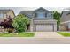 Two-story home with two-car garage, lawn, brick accents, and lovely curb appeal at 7345 S Nucla St, Aurora, CO 80016