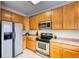 Well-lit kitchen featuring stainless steel appliances, wooden cabinets, and neutral countertops at 7345 S Nucla St, Aurora, CO 80016