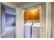 Convenient laundry area with washer, dryer, and storage cabinets for supplies at 7345 S Nucla St, Aurora, CO 80016