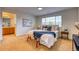 Bright main bedroom with a bench seat, ensuite access, and a large window overlooking the yard at 7345 S Nucla St, Aurora, CO 80016