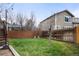 Grassy backyard with a wooden fence and mature trees, offering privacy and space for outdoor enjoyment at 11032 Cannonade Ln, Parker, CO 80138