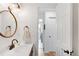 Well-lit bathroom featuring a modern sink, brushed gold accents, and an adjacent laundry area at 11032 Cannonade Ln, Parker, CO 80138