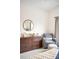 Bedroom features dresser with round mirror, chair, ottoman, and neutral walls at 11032 Cannonade Ln, Parker, CO 80138
