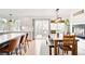Bright dining area featuring a large dining table, sliding glass doors to the deck, and a kitchen island with stools at 11032 Cannonade Ln, Parker, CO 80138