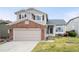 Charming two-story home featuring a brick-accented garage and well-maintained front yard, creating a welcoming curb appeal at 11032 Cannonade Ln, Parker, CO 80138
