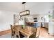 Open-concept kitchen and dining area with a wooden table, island seating, and stainless steel appliances at 11032 Cannonade Ln, Parker, CO 80138