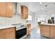 Beautiful kitchen featuring stainless steel stove and range hood with view to the fireplace and living room at 2800 Albion St, Denver, CO 80207