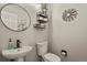 Stylish powder room with modern fixtures, decorative mirror and floating shelves at 5405 S Sicily St, Aurora, CO 80015