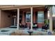 Charming front porch featuring brick columns, comfortable seating, and stylish decor at 5405 S Sicily St, Aurora, CO 80015