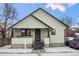 Quaint yellow house with a covered porch and snow-covered yard at 141 N 5Th Ave, Brighton, CO 80601