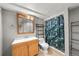 Bathroom featuring a wood vanity and a shower with a green leaf-patterned curtain at 16650 E Nassau Dr, Aurora, CO 80013