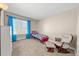Bright bedroom featuring a twin bed, comfortable rocking chair and ample natural light at 16650 E Nassau Dr, Aurora, CO 80013