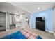 Comfortable bedroom with a closet, featuring blue accent wall and a modern black dresser with a TV at 16650 E Nassau Dr, Aurora, CO 80013