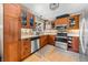 Modern kitchen featuring stainless steel appliances, wooden cabinetry, and a decorative backsplash at 16650 E Nassau Dr, Aurora, CO 80013