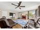 Bright living room featuring hardwood floors, a red brick fireplace, and comfortable seating at 16650 E Nassau Dr, Aurora, CO 80013