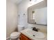 This half-bathroom features a white toilet and a vanity with a cream-colored sink and dark faucet at 10329 W Fair Ave # C, Littleton, CO 80127