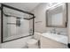 This renovated bathroom features black and white tiles, a marble vanity, and a glass-enclosed bathtub at 10329 W Fair Ave # C, Littleton, CO 80127