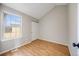 This bedroom is brightly lit, featuring hardwood floors and a large window with a view to the outside at 10329 W Fair Ave # C, Littleton, CO 80127