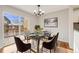 Modern dining room with glass table, area rug, elegant chandelier, sliding glass door to a deck, and hardwood floors at 10329 W Fair Ave # C, Littleton, CO 80127
