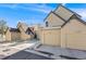 Townhome exterior view featuring attached garages, sidewalk, and wintery ground at 10329 W Fair Ave # C, Littleton, CO 80127