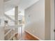 Hallway featuring wood floors and a staircase, leading to a bright living space with access to a balcony at 10329 W Fair Ave # C, Littleton, CO 80127