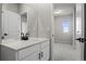 Bright bathroom boasts a white vanity with black fixtures, and a doorway view into a carpeted bedroom at 27492 E 1St Ave, Aurora, CO 80018