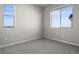 Bright bedroom featuring two windows allowing ample natural light to illuminate its neutral decor and gray carpeting at 27492 E 1St Ave, Aurora, CO 80018