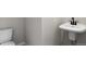 White half-bathroom featuring a wall-mounted sink, modern fixtures, and tile flooring at 27492 E 1St Ave, Aurora, CO 80018