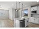 Bright kitchen featuring an island with sink, modern faucet, and stainless steel dishwasher at 27492 E 1St Ave, Aurora, CO 80018