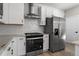 Modern kitchen with stainless steel appliances, white cabinets, subway tile backsplash, and quartz countertops at 27492 E 1St Ave, Aurora, CO 80018