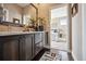 Bathroom vanity with dark wood cabinets, decor, and a mirror that leads to the bedroom at 15569 W La Salle Ave, Lakewood, CO 80228