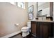Charming powder room featuring a dark wood vanity, artwork, and wood-look floors at 15569 W La Salle Ave, Lakewood, CO 80228