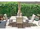 Relaxing outdoor patio with table, chairs, umbrella, and a lush green backdrop at 15569 W La Salle Ave, Lakewood, CO 80228