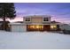 Two-story house with attached two-car garage, covered porch, and snow-covered yard at 10350 W Burgundy Ave, Littleton, CO 80127