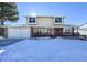 Two-story house with attached garage and snow-covered front yard at 10350 W Burgundy Ave, Littleton, CO 80127