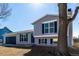 Bi-level home with a two-car garage, gray paint and blue shutters at 4752 E 108Th Pl, Thornton, CO 80233