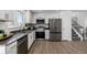 Modern kitchen featuring stainless steel appliances, gray countertops, and wood floors at 4752 E 108Th Pl, Thornton, CO 80233