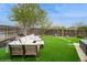 A backyard with an artificial lawn and a wooden fence with an outdoor seating area at 483 S Kingston Cir, Aurora, CO 80012