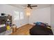 Bright bedroom with wood floors, ceiling fan, shelving unit, and window with white shutters at 483 S Kingston Cir, Aurora, CO 80012