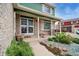 A well-decorated front porch with brick columns, a green ceiling, and a decorative security door at 483 S Kingston Cir, Aurora, CO 80012