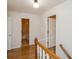 Hallway with wood floors leads to bathroom with tile floor and a second room with a baby gate at 483 S Kingston Cir, Aurora, CO 80012