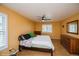 Main bedroom with yellow walls, wood floor, ceiling fan, and windows with white shutters at 483 S Kingston Cir, Aurora, CO 80012