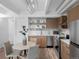 Modern kitchen with stainless steel appliances, light wood cabinetry, and a cozy dining area at 1495 Vrain St # 214, Denver, CO 80204