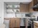 Modern kitchen featuring stainless steel appliances, wood cabinets, and open shelving for a contemporary design at 1495 Vrain St # 214, Denver, CO 80204