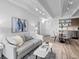 Bright living room featuring a comfortable gray sofa, modern decor, and seamless flow into the dining and kitchen areas at 1495 Vrain St # 214, Denver, CO 80204