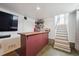 Basement bar with wood countertop, under-counter fridge, and staircase to upper level at 4504 N Clay St, Denver, CO 80211