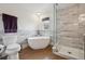Serene bathroom with soaking tub, glass enclosed shower, neutral tiles and wood floors at 4504 N Clay St, Denver, CO 80211