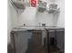 Convenient laundry room featuring front loading washer and dryer units with storage shelves above at 4504 N Clay St, Denver, CO 80211