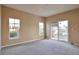 Neutral bedroom featuring carpeted floor, a sliding door and two windows at 9429 Ashbury Cir # 101, Parker, CO 80134