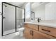 Bathroom featuring wood cabinets, a glass-enclosed shower, and natural light at 1694 Fox Trotter Pt, Castle Rock, CO 80104